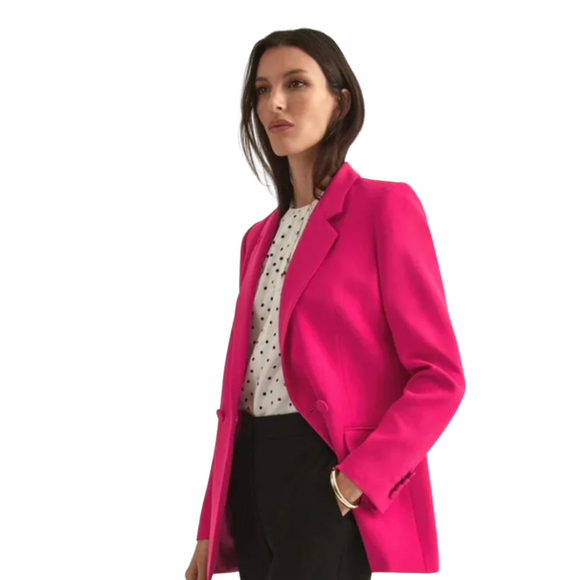 a woman with brunette hair wearing a pink suit jacket and blouse 